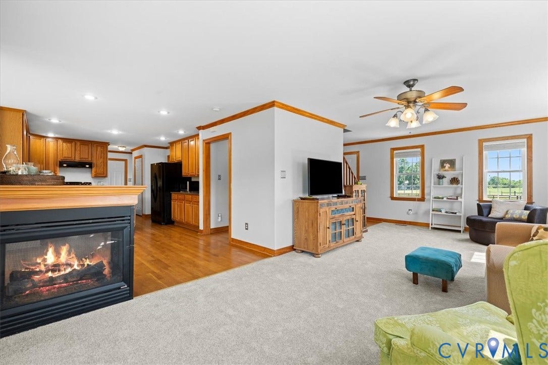 Carpeted living space with light gray walls and wood-finish trim