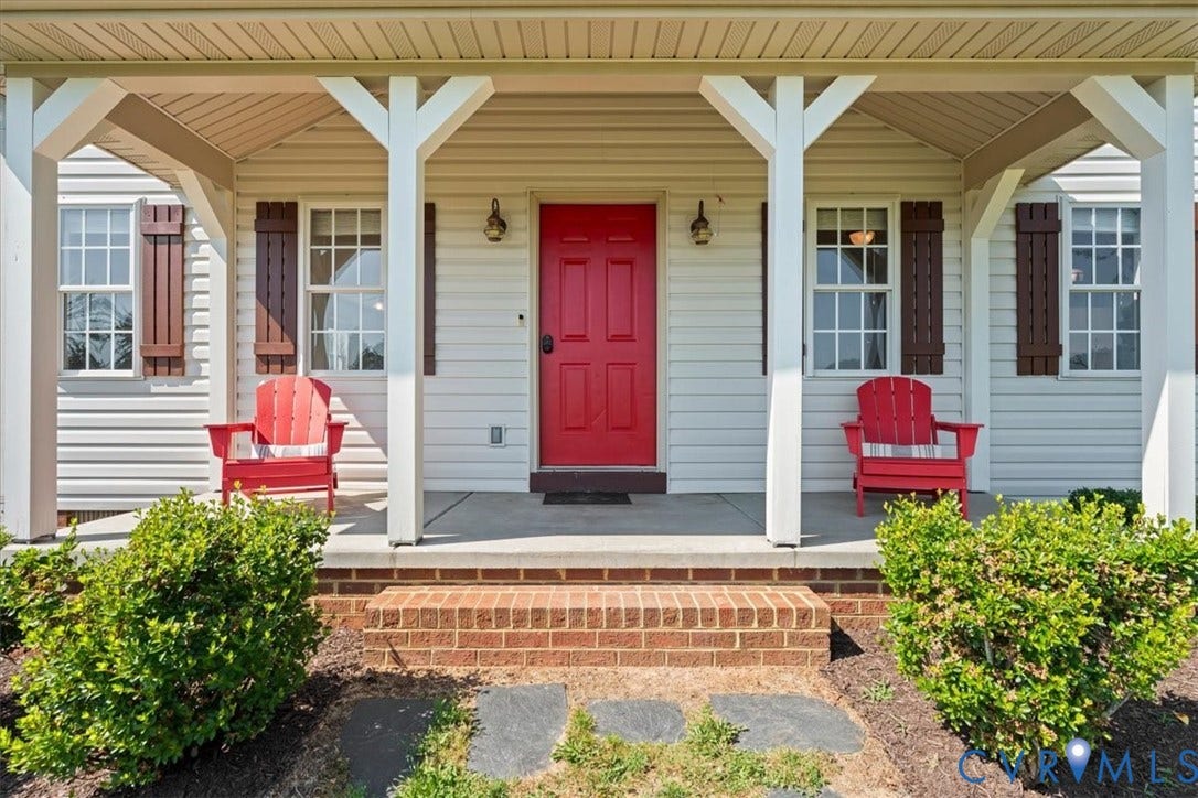 Welcoming front porch featuring white columns and a vibrant red door