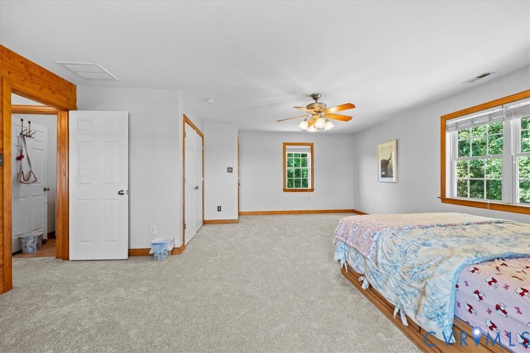 Spacious room featuring light gray wall paint and wood-finish accent walls