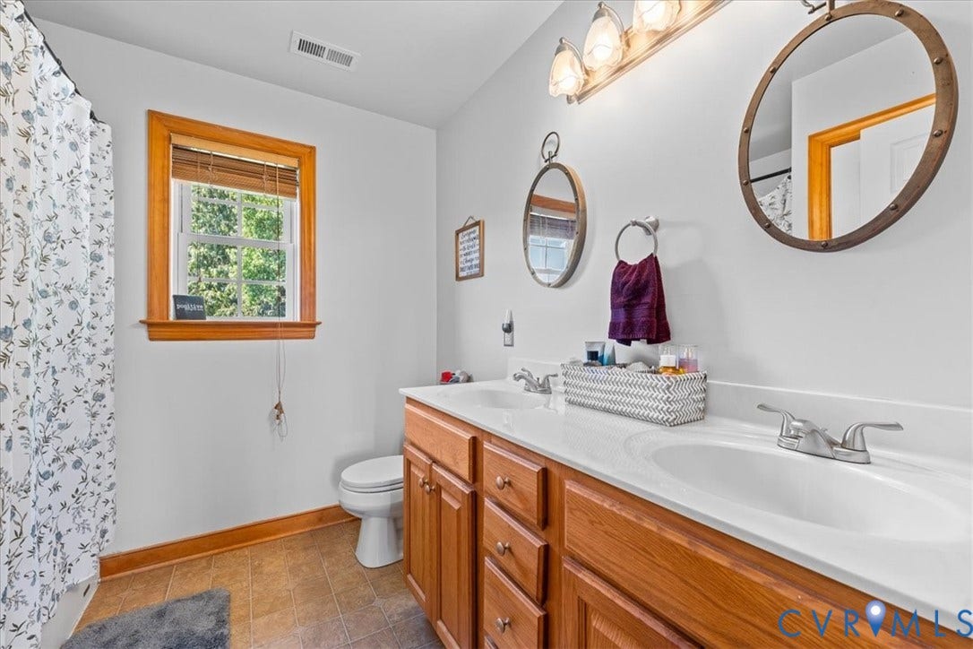 Primary bedroom featuring light neutral wall paint, light-colored carpeting, and wood-finish trim