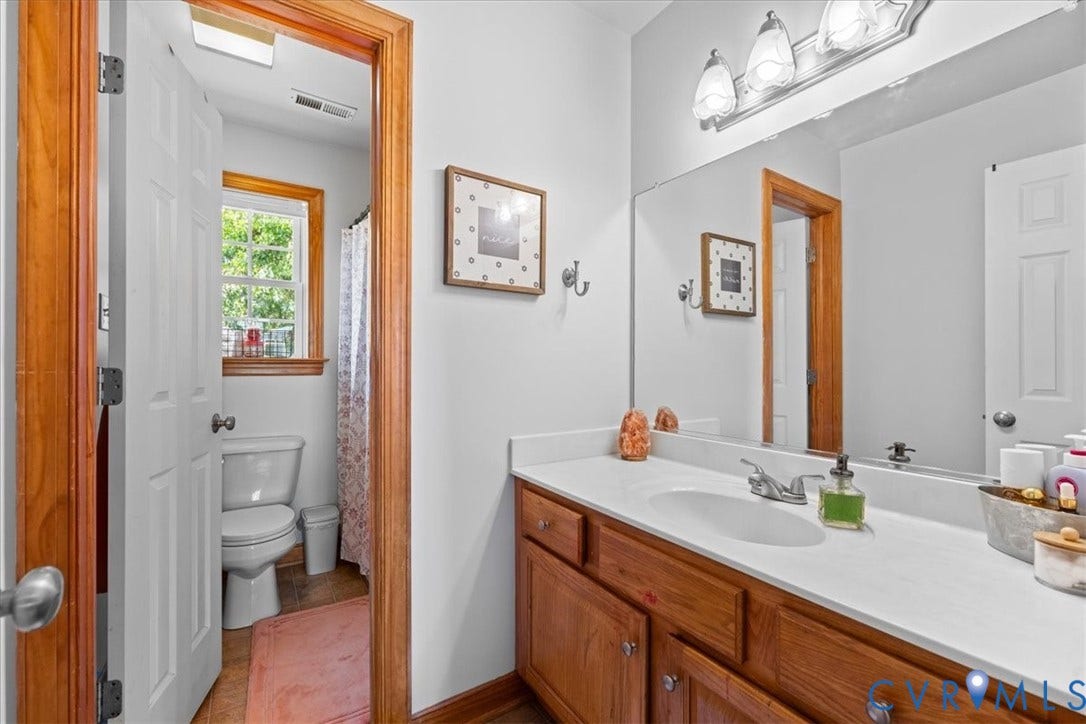 Interior room featuring light gray carpeting, white walls, and wood trim