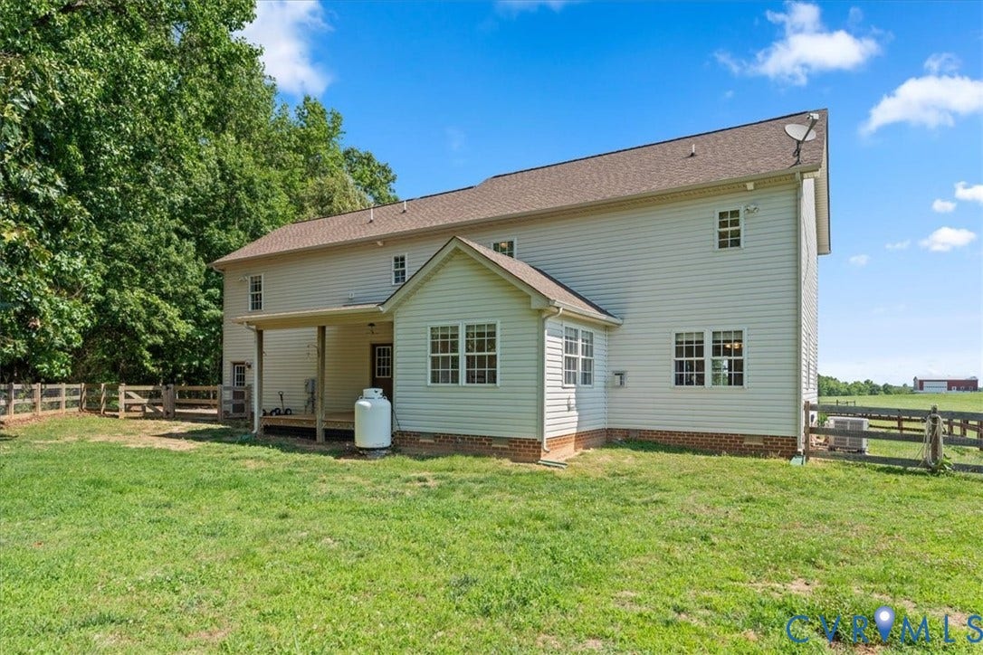 Expansive rear exterior featuring siding, brick foundation, covered porch, and sunroom addition
