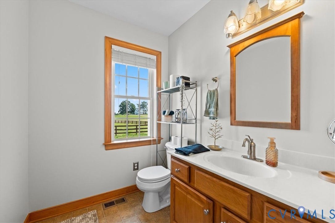 Bathroom featuring a single vanity with wood cabinetry, a white countertop, and an undermount sink