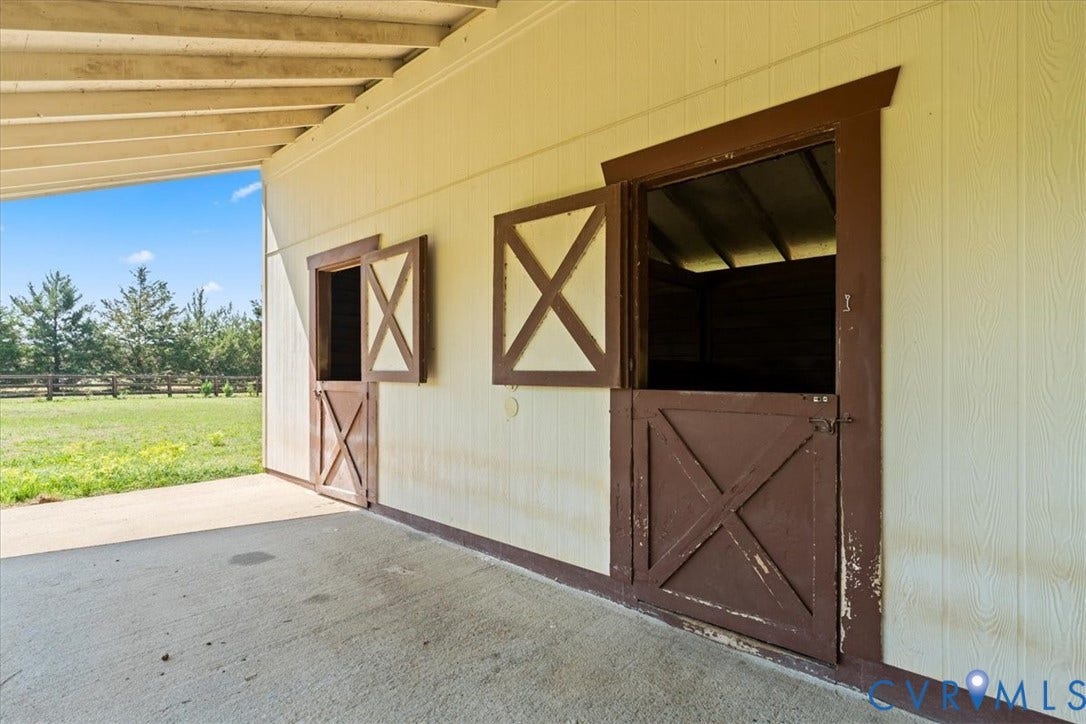 Exterior structure featuring wood-finish siding, a concrete patio, and an open-beam ceiling