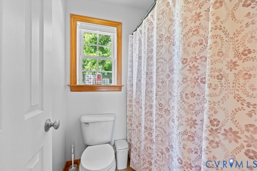 Bathroom vanity featuring a light-toned countertop with integrated sink, chrome-finish faucet, and warm wood-toned cabinetry