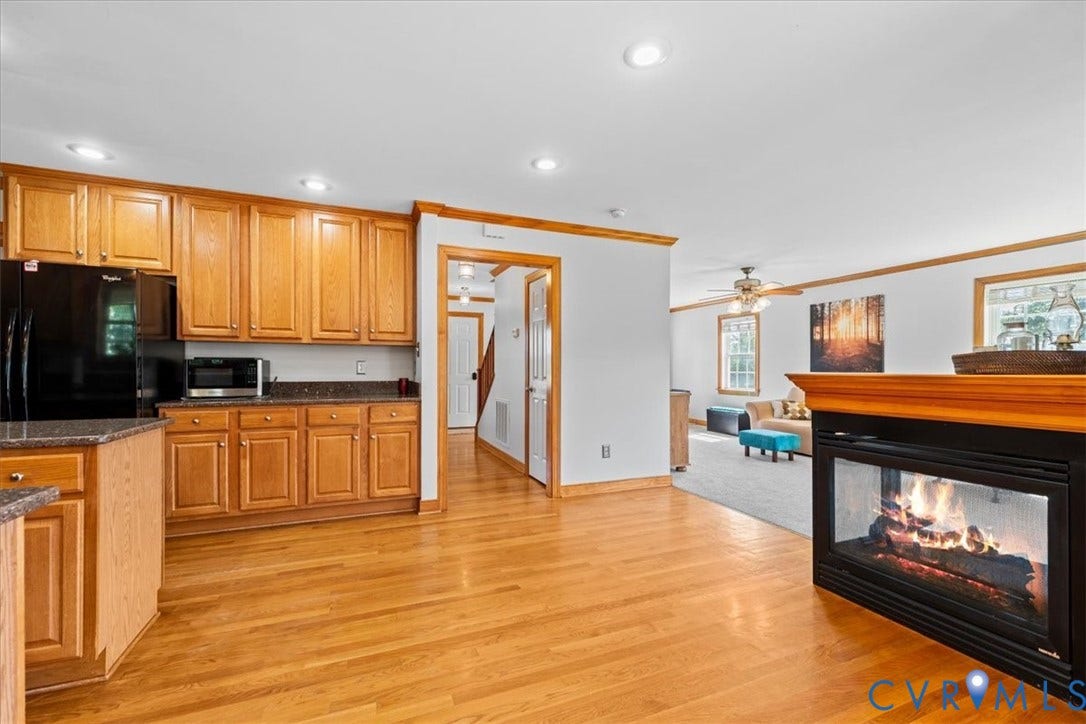 Kitchen featuring wood cabinetry, a center island with a stone-finish countertop, and recessed lighting