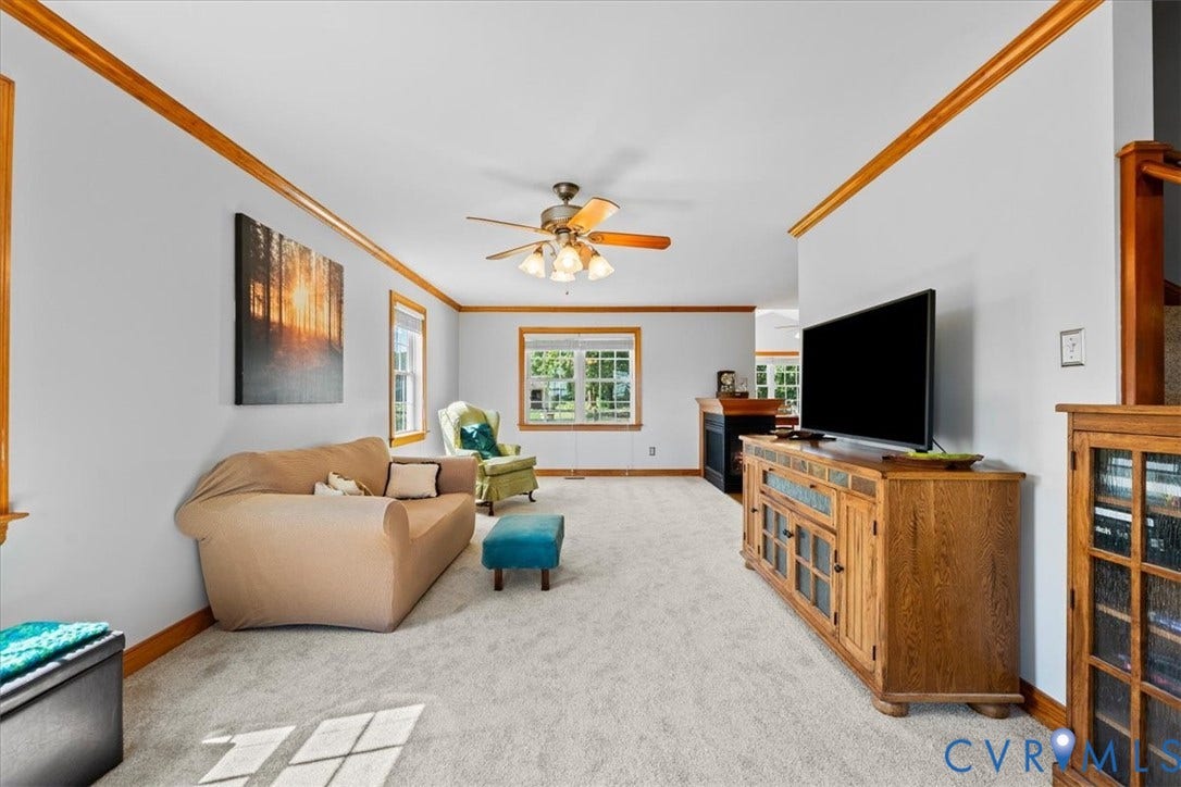 Hardwood-style flooring throughout a spacious room featuring a wooden staircase, white walls, and wood trim