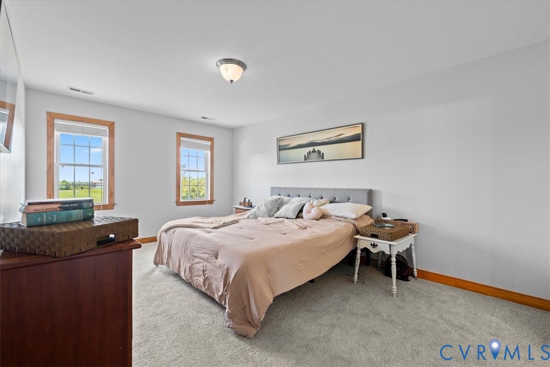 Hallway featuring neutral carpet flooring, white paneled doors with wood trim, and a wood-capped half wall