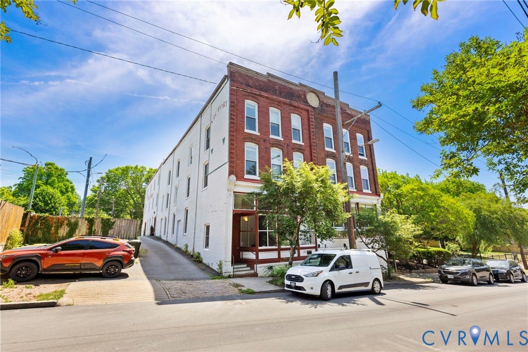 407 S Cherry Street, #U202, Oregon Hill, Richmond, VA 23220 Brick and white painted multi-story building featuring multiple windows and a street-level entrance