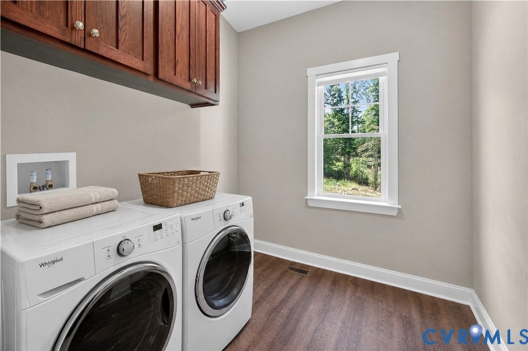 3834 Three Chopt Road, Nonw, Goochland, VA 23065 Laundry area featuring wood-finish flooring, overhead cabinetry with gold-toned hardware, and a single window