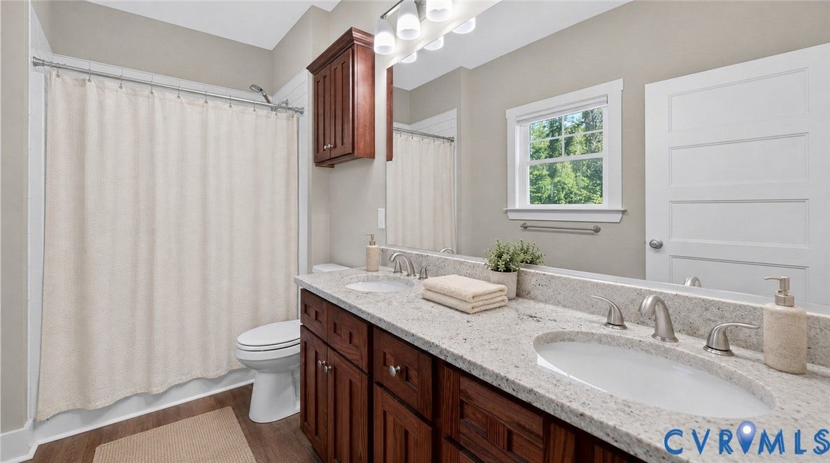 3834 Three Chopt Road, Nonw, Goochland, VA 23065 Dual vanity with integrated sinks, speckled countertop, and wood-finish cabinetry
