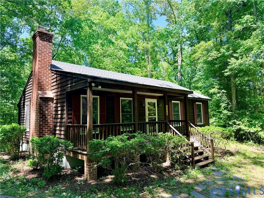 2590 Davis Mill Road, Fife, Goochland, VA 23063 Wood-sided residence featuring a covered front porch with wood railings and steps