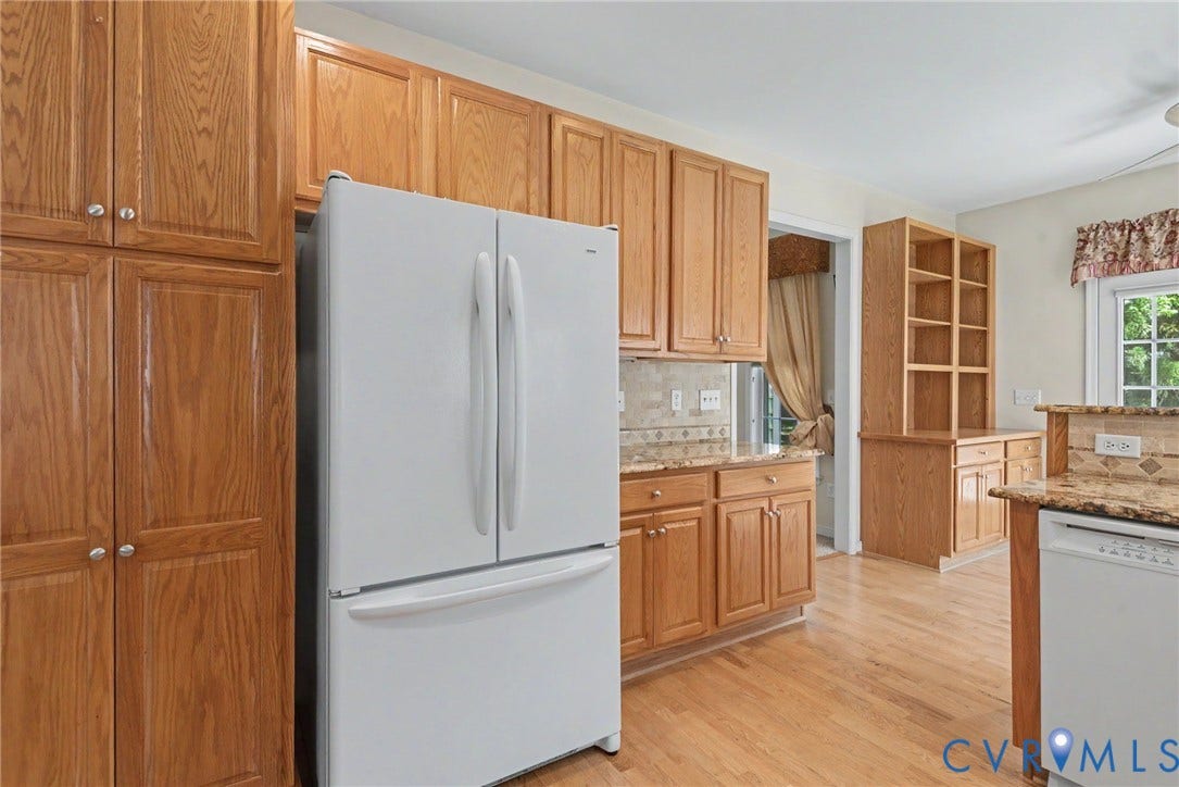 Kitchen featuring wood-finish cabinetry, granite countertops, and tile backsplash