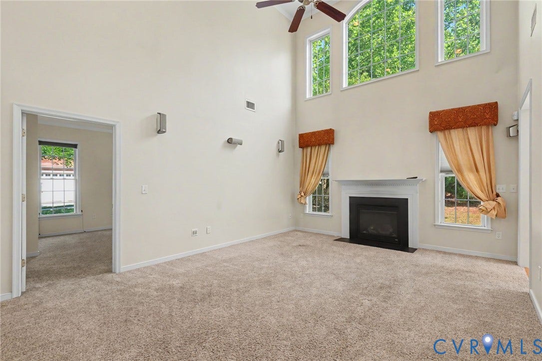 Great room featuring a fireplace with a white mantel, high vaulted ceilings, and a ceiling fan
