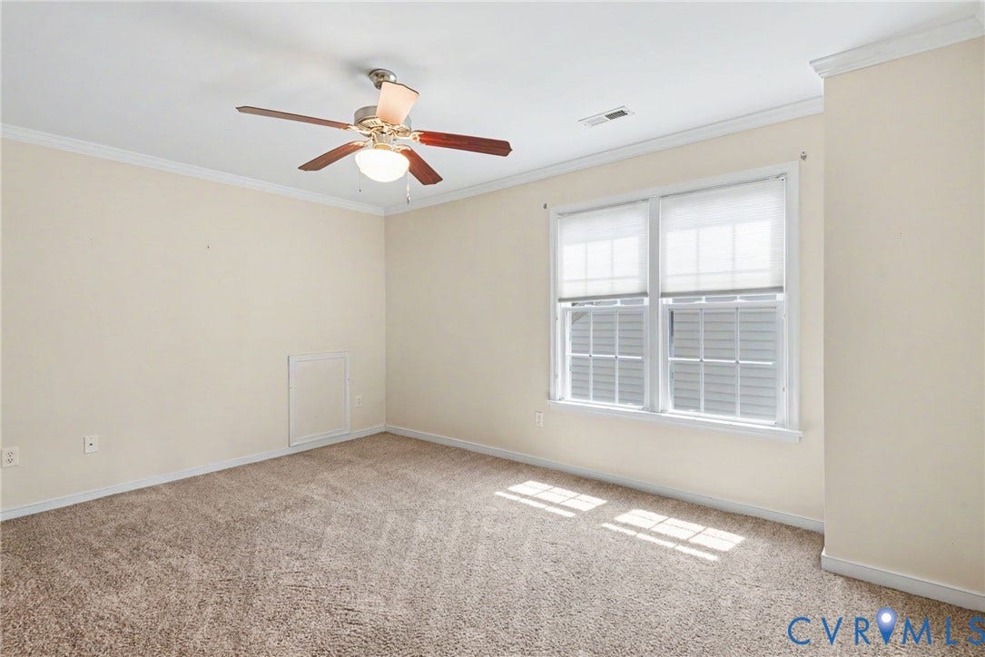 Carpeted room featuring a ceiling fan with light fixture, double window with blinds, and white crown molding