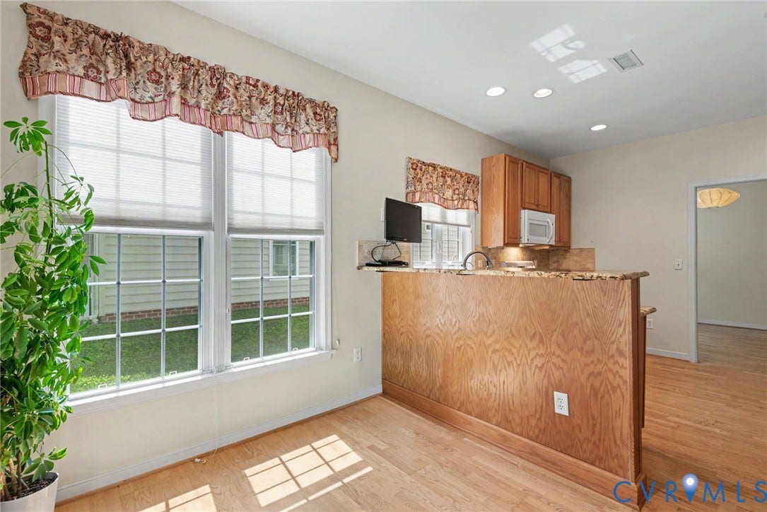 Kitchen area featuring a wood-finish peninsula with a stone-finish countertop, wood cabinetry, and recessed lighting
