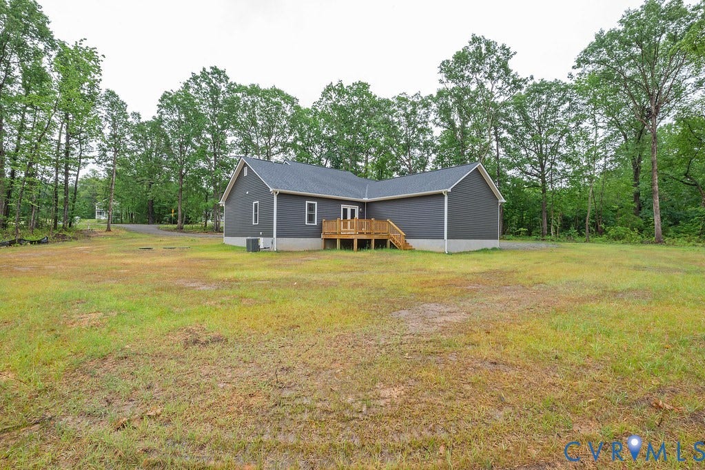 9256 Fredericks Hall Road, Con Creek, Mineral, VA 23117 Modern ranch-style home featuring dark gray siding, a charcoal shingle roof, and a wood deck with stairs
