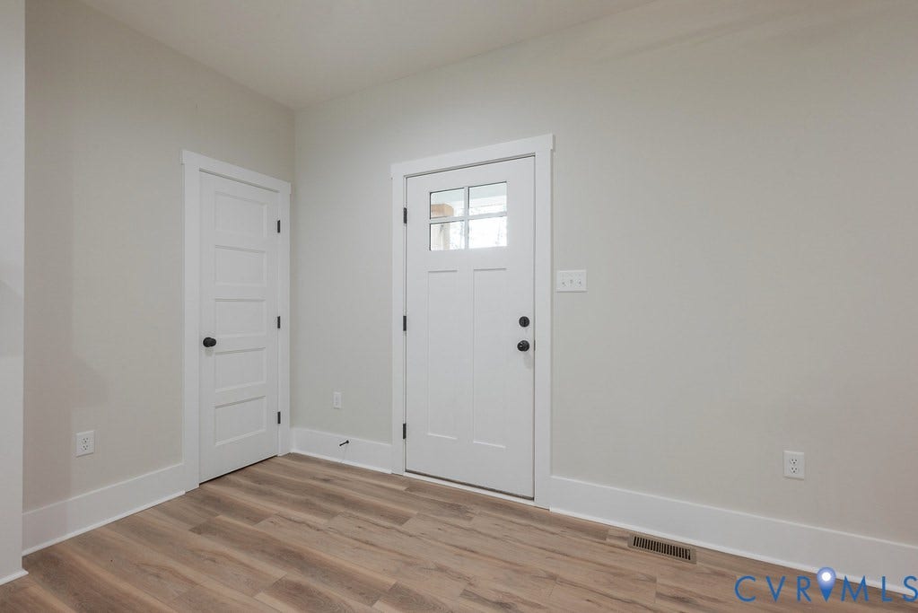 9256 Fredericks Hall Road, Con Creek, Mineral, VA 23117 Entryway featuring a Craftsman-style door with clear glass panels, wood-finish flooring, white trim, and light gray wall paint