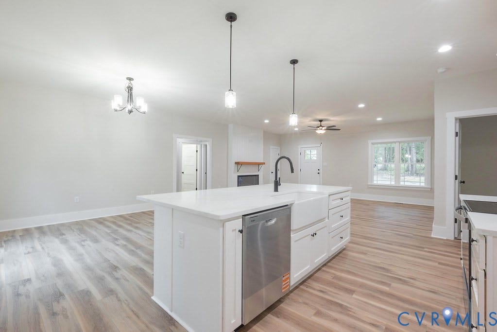 9256 Fredericks Hall Road, Con Creek, Mineral, VA 23117 Open concept kitchen and living area featuring a central island with white cabinetry and a farmhouse sink, stainless steel dishwasher, wood-finish flooring, and recessed lighting