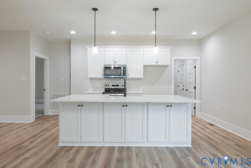 9256 Fredericks Hall Road, Con Creek, Mineral, VA 23117 Kitchen island featuring a white countertop, pendant lighting, white cabinetry, and stainless steel appliances