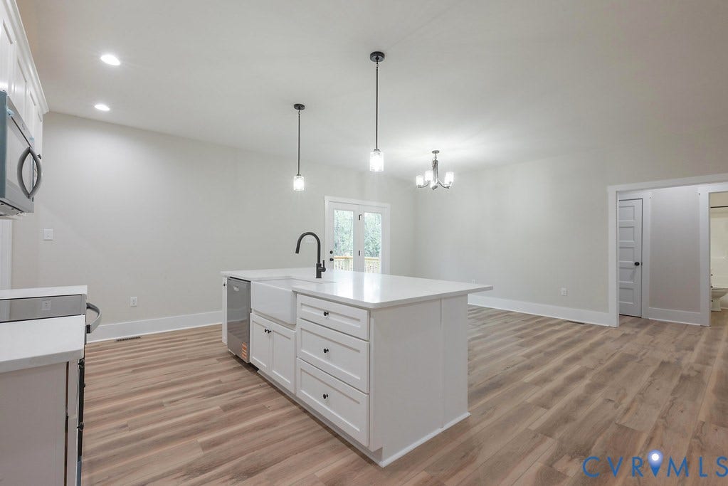 9256 Fredericks Hall Road, Con Creek, Mineral, VA 23117 Kitchen island featuring a farmhouse sink, stainless steel dishwasher, and a matte black faucet