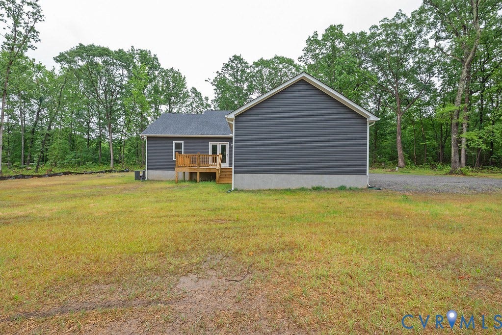 9256 Fredericks Hall Road, Con Creek, Mineral, VA 23117 Rear exterior showcasing dark gray siding, a wood deck, and a white framed glass door
