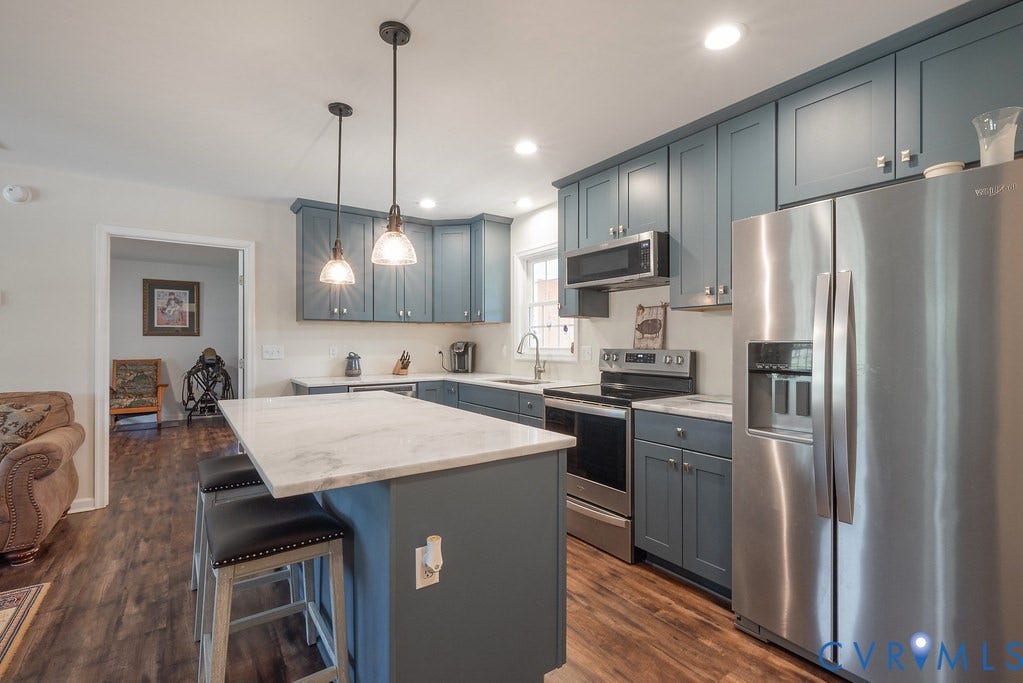 4336 Hells Bend Road, Quiet And Private, Palmyra, VA 22963 Contemporary kitchen featuring blue cabinetry, stainless steel appliances, marble-look countertops, a kitchen island with pendant lighting, and wood-finish flooring