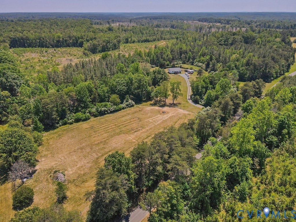 4336 Hells Bend Road, Quiet And Private, Palmyra, VA 22963 Expansive rural property featuring a single-story residence, a paved driveway, a cleared field, and abundant surrounding woodlands