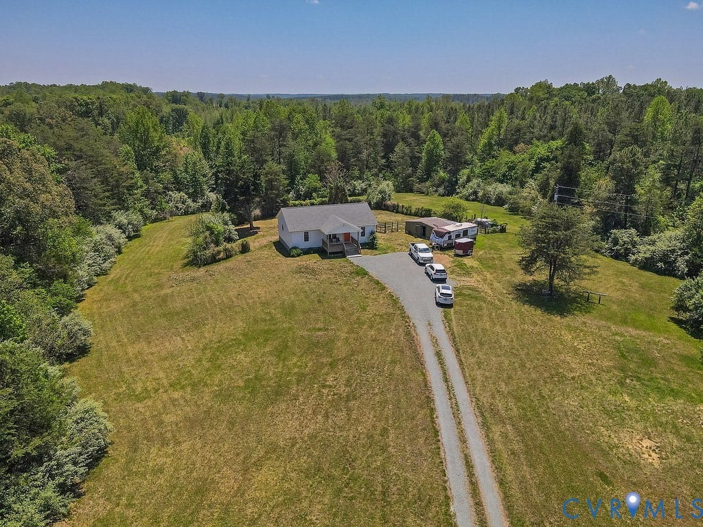 4336 Hells Bend Road, Quiet And Private, Palmyra, VA 22963 Expansive property featuring a white single-story residence with a red front door, a gravel driveway, a detached shed, and abundant surrounding greenery