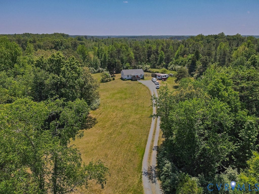 4336 Hells Bend Road, Quiet And Private, Palmyra, VA 22963 Expansive property featuring a gravel driveway and a white-sided residence set amidst a heavily wooded landscape