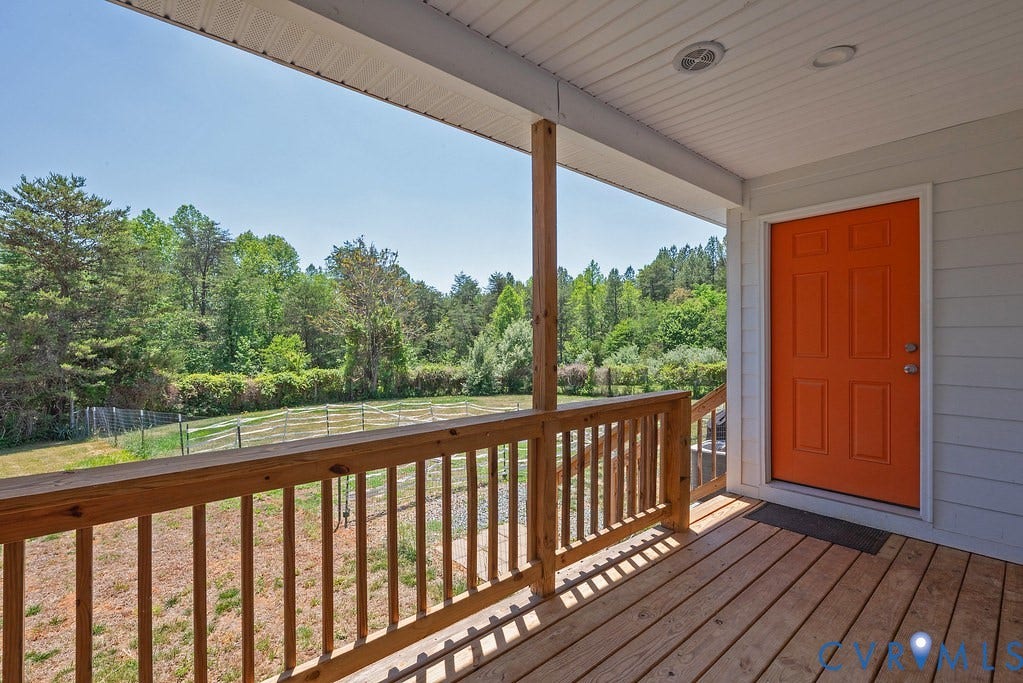 4336 Hells Bend Road, Quiet And Private, Palmyra, VA 22963 Covered wooden porch featuring an orange entry door, wood-finish decking, and natural wood railings