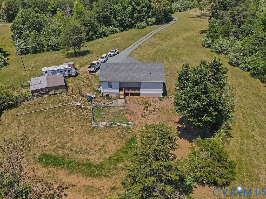 4336 Hells Bend Road, Quiet And Private, Palmyra, VA 22963 Single-story residence on a sloped, expansive property featuring a gravel driveway, mature trees, and a distant treeline