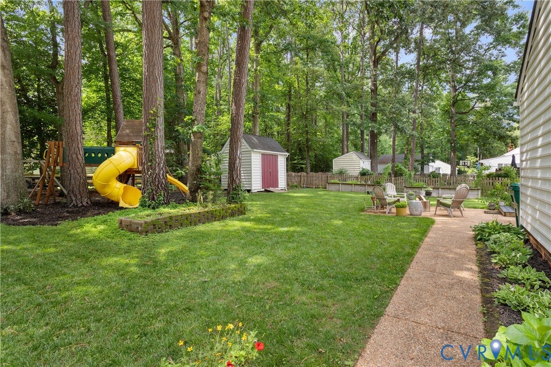 10100 Contessa Court, Glen Allen, VA 23060 Expansive backyard featuring mature trees, a manicured lawn, and a paved pathway
