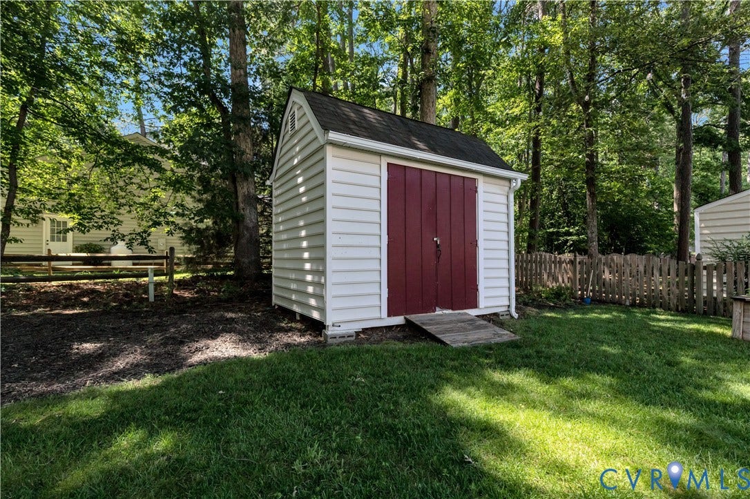 10100 Contessa Court, Glen Allen, VA 23060 Backyard storage shed featuring white horizontal siding, a dark red double door, and a shingled gable roof