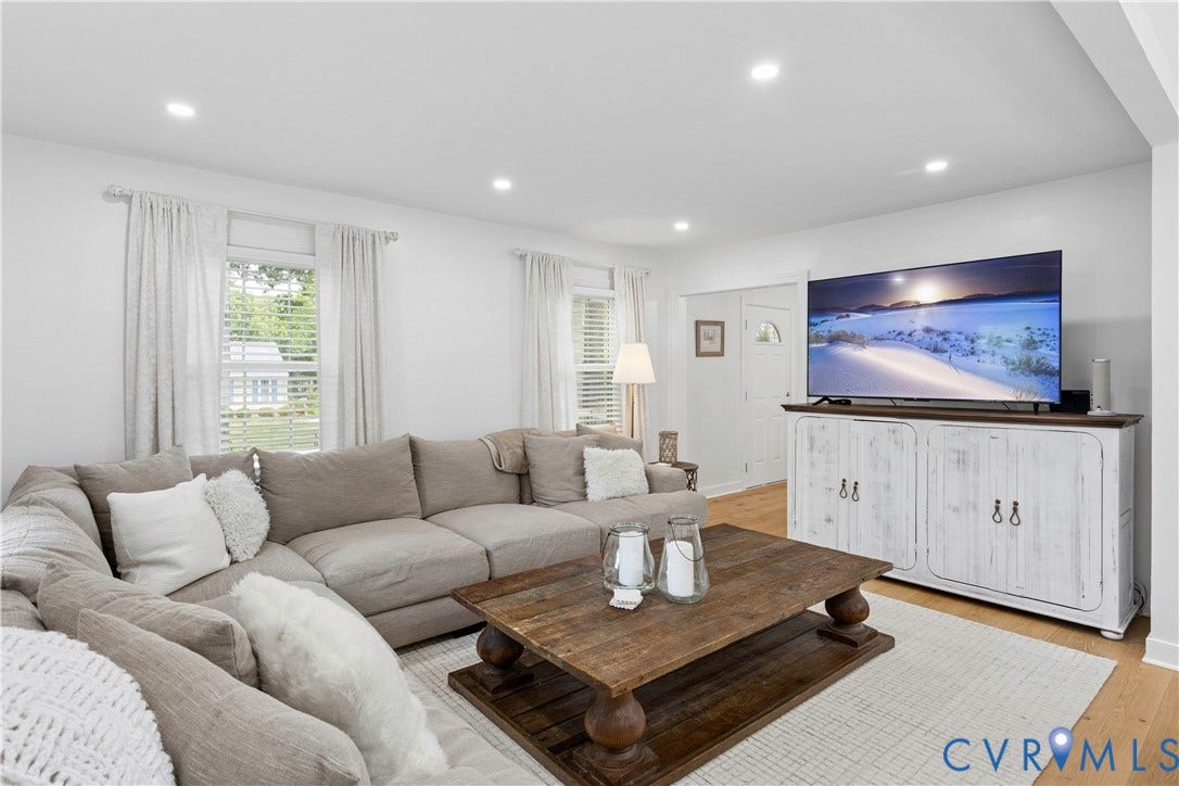 10100 Contessa Court, Glen Allen, VA 23060 Bright living room featuring light wood-finish flooring, recessed lighting, multiple windows with blinds, and a white entrance door with a decorative glass insert