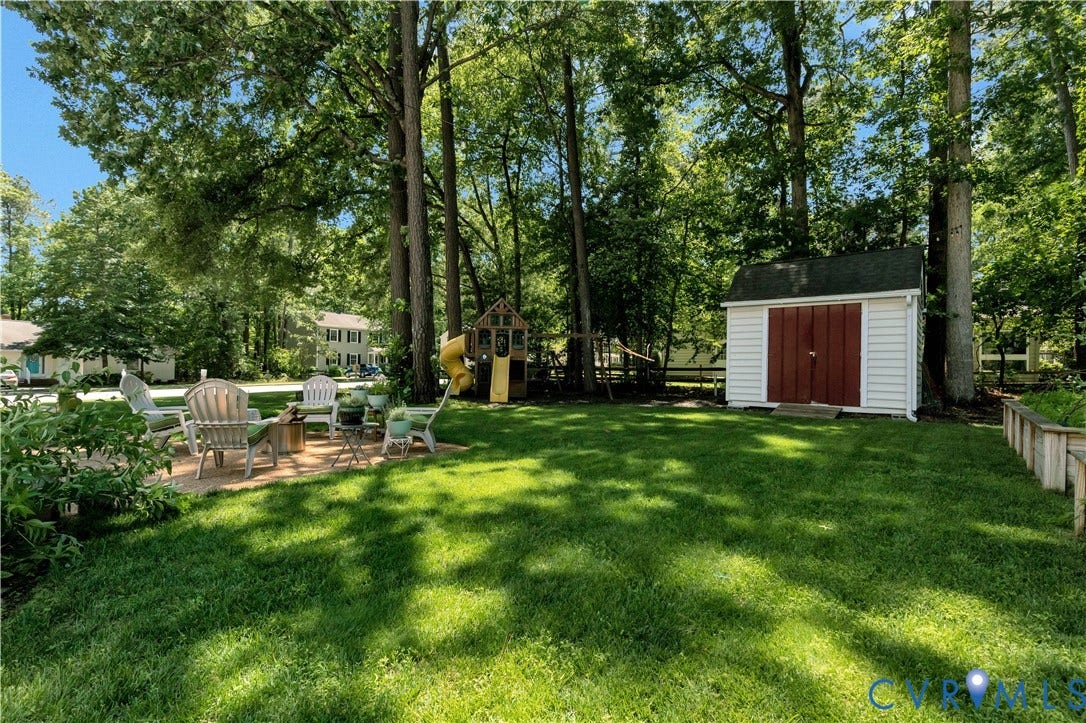 10100 Contessa Court, Glen Allen, VA 23060 Expansive backyard featuring a lush lawn, mature trees, and a paver patio