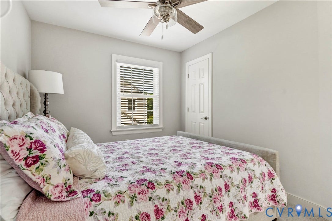 10100 Contessa Court, Glen Allen, VA 23060 Neutral-toned room with a ceiling fan featuring wood-finish blades, a white window with horizontal blinds, and a paneled door