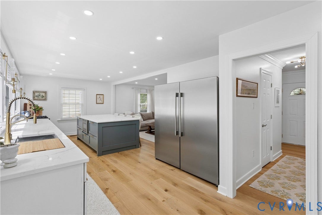 10100 Contessa Court, Glen Allen, VA 23060 Kitchen featuring a large central island with integrated microwave, stainless steel French door refrigerator, light wood-finish flooring, recessed lighting, and white countertops with an undermount sink and gold-tone faucet