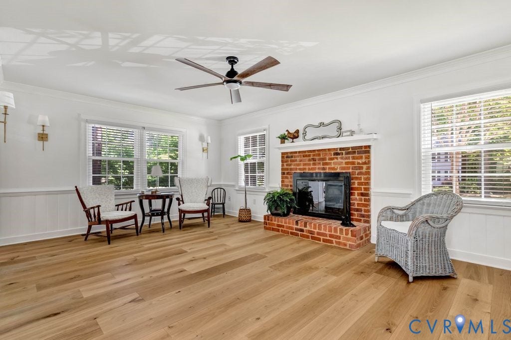 10100 Contessa Court, Glen Allen, VA 23060 Spacious interior featuring wood-finish flooring, a brick fireplace with mantel, white wainscoting, and multiple windows