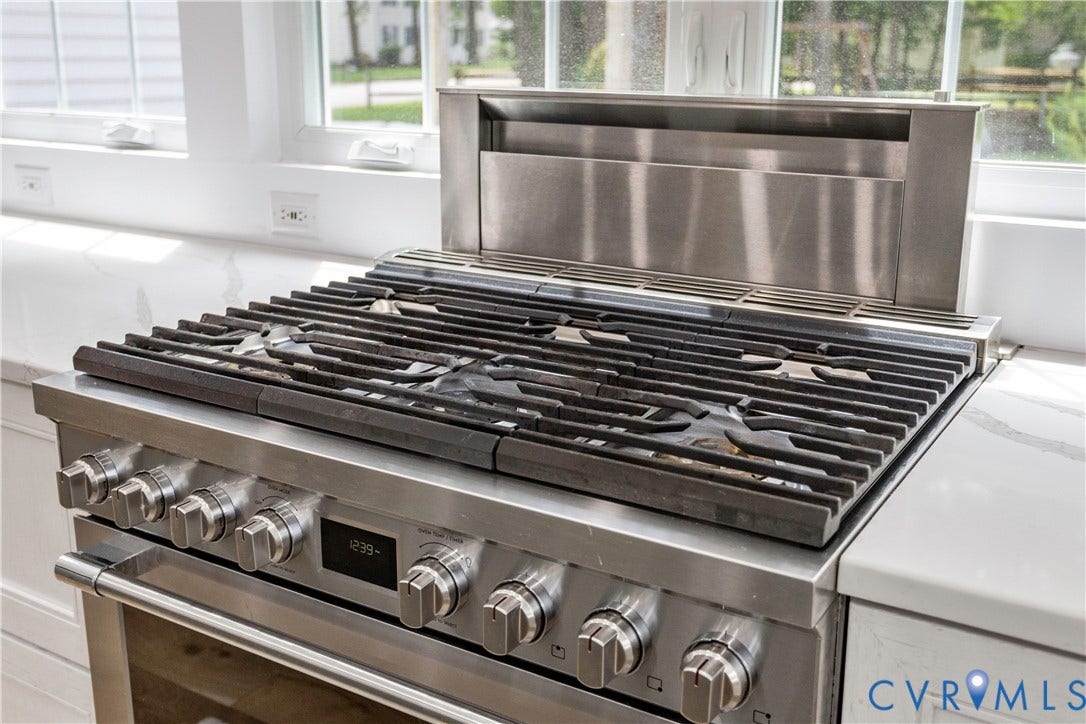 10100 Contessa Court, Glen Allen, VA 23060 Stainless steel range featuring a built-in downdraft ventilation system, continuous grates, and front-mounted controls