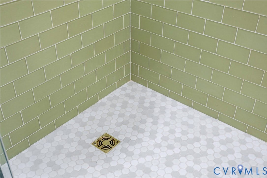 10100 Contessa Court, Glen Allen, VA 23060 Shower stall featuring light green subway tile walls and a hexagonal mosaic tile floor with a bronze-toned drain