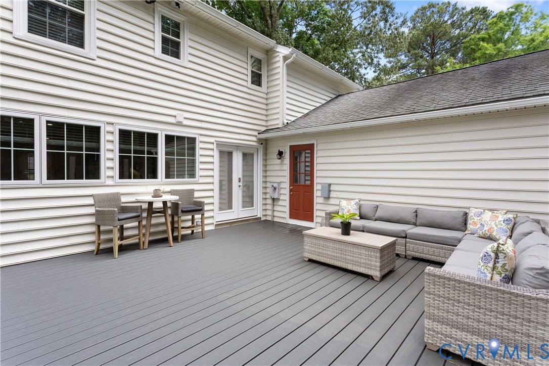 10100 Contessa Court, Glen Allen, VA 23060 Spacious grey composite deck featuring a red entry door, white double French doors, white siding, and multiple windows