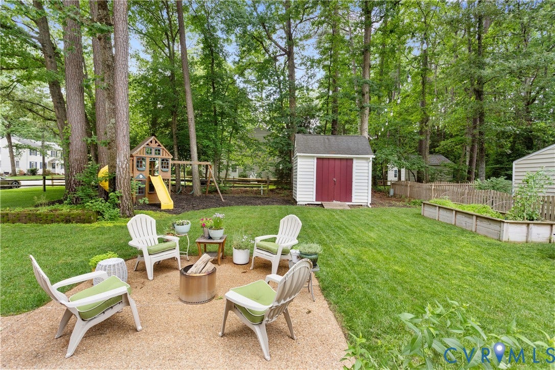 10100 Contessa Court, Glen Allen, VA 23060 Expansive backyard featuring a gravel patio, mature trees, a storage shed, and raised garden beds