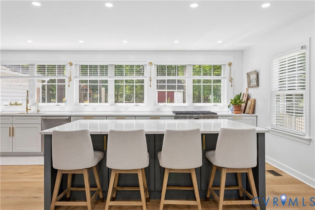 10100 Contessa Court, Glen Allen, VA 23060 Kitchen featuring a large island with seating, white shaker-style perimeter cabinetry, light wood-finish flooring, and a stainless steel dishwasher