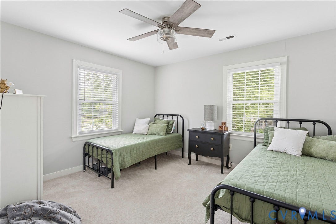 10100 Contessa Court, Glen Allen, VA 23060 Neutral-toned room featuring a ceiling fan, two windows with blinds, and light-colored carpeting