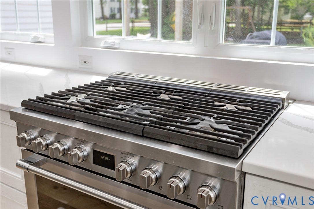 10100 Contessa Court, Glen Allen, VA 23060 Stainless steel range with a built-in griddle and multiple burners, set into a white countertop