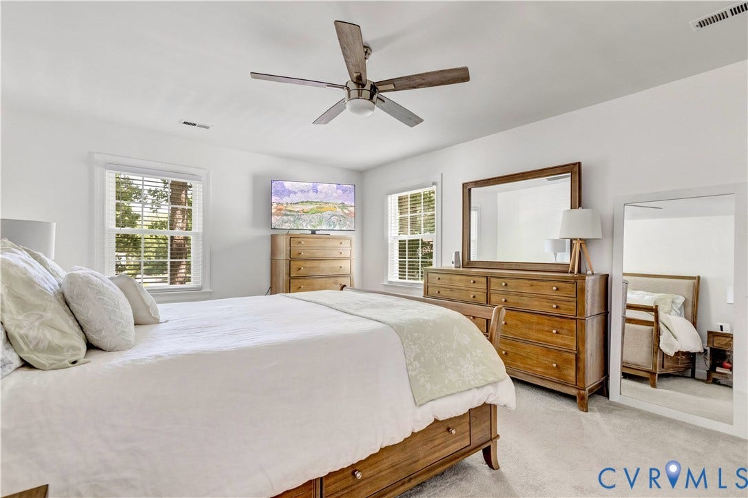 10100 Contessa Court, Glen Allen, VA 23060 Bright bedroom featuring two windows with white blinds, light gray carpeting, a ceiling fan with wood-look blades, and white painted walls