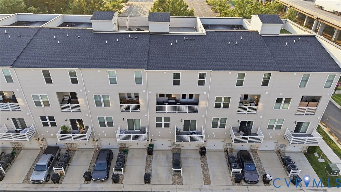 1121 N Lombardy Street, #B, Carver Square, Richmond, VA 23220 Contemporary townhome exteriors featuring light-colored siding, dark shingle roofs, and individual balconies with white railings