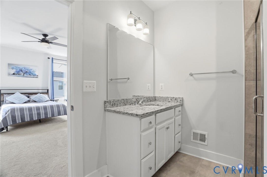 1121 N Lombardy Street, #B, Carver Square, Richmond, VA 23220 Bathroom vanity featuring a light-toned countertop, white cabinetry, and a framed mirror with overhead lighting