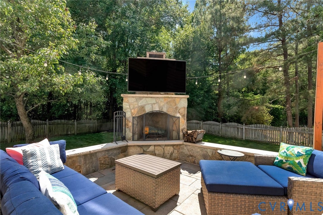 12300 Reed Forest Court, Wyndham, Glen Allen, VA 23059 Patio spans the entire rear of the home! The stone front Wood- burning fireplace w/ TV above is lots of fun in football season! The TV & its cover conveys!
